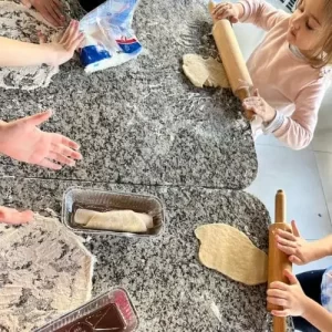 Crianças participando de oficina infantil de pães em evento em Americana