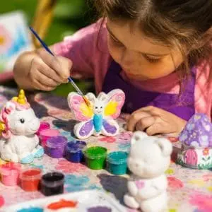 menina pintando em gesso na oficina infantil pintura tela da tia rita festas