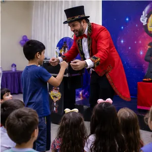 Show de mágica em evento infantil com plateia de crianças animadas